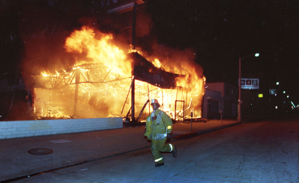 A Los Angeles City fireman responds to a building fire in South Central Los Angeles